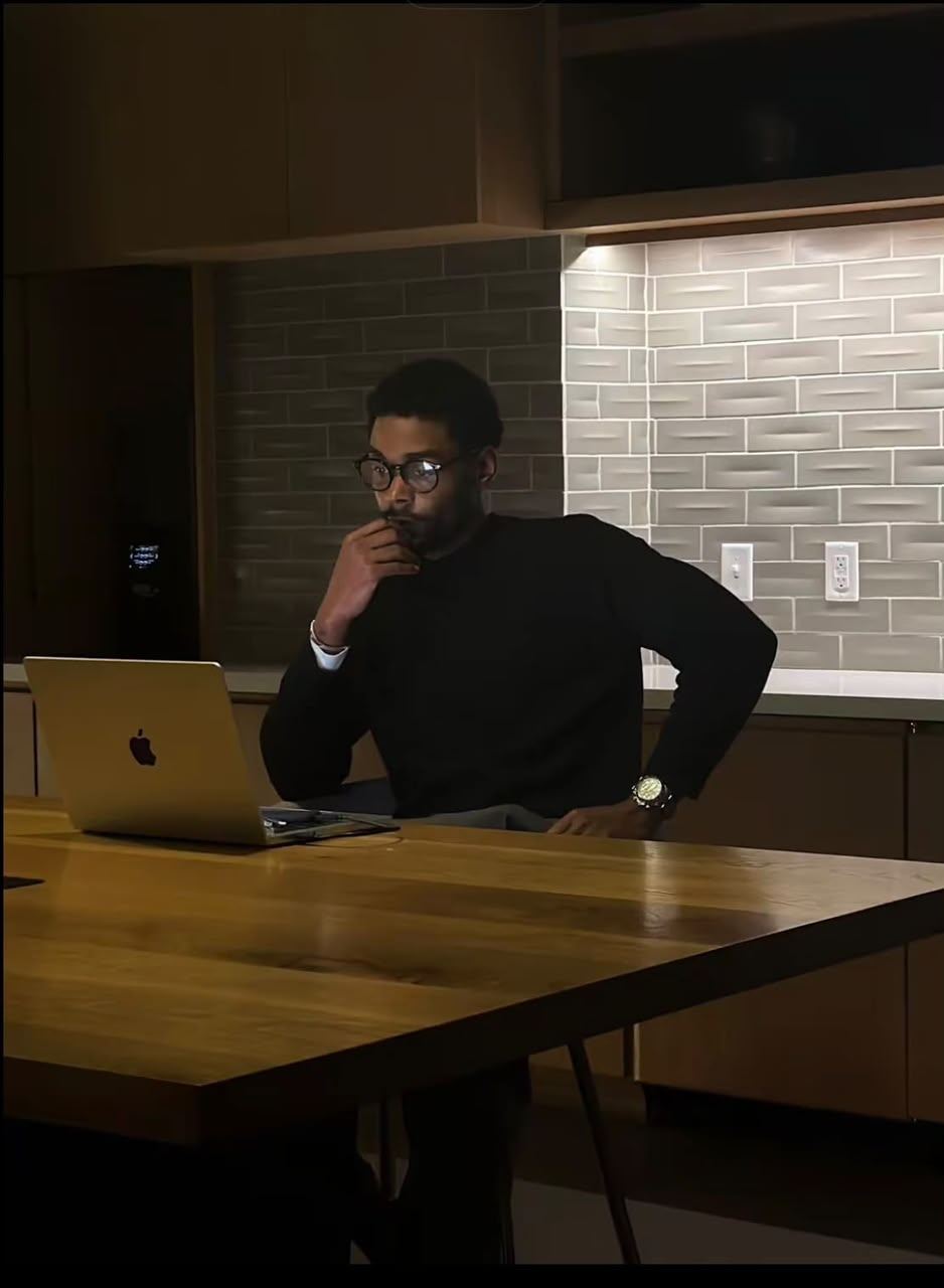 Man thinking at his laptop late in the evening